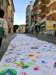 Polverigi abbraccia la pace: la Eco-Bandiera più lunga del mondo colora il centro storico
